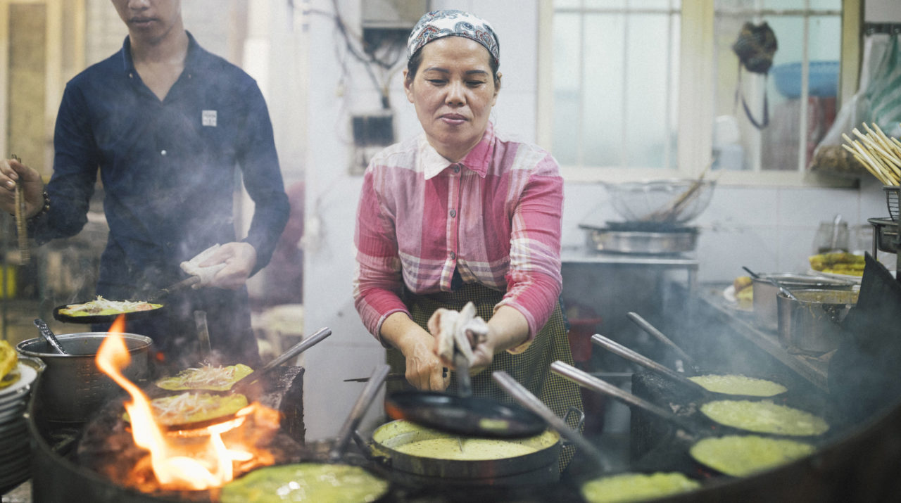 A local cook is making Bánh Xèo (also known as Vietnamese pancake)